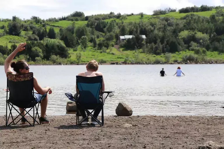 People sitting by Hvaleyrarvatn lake