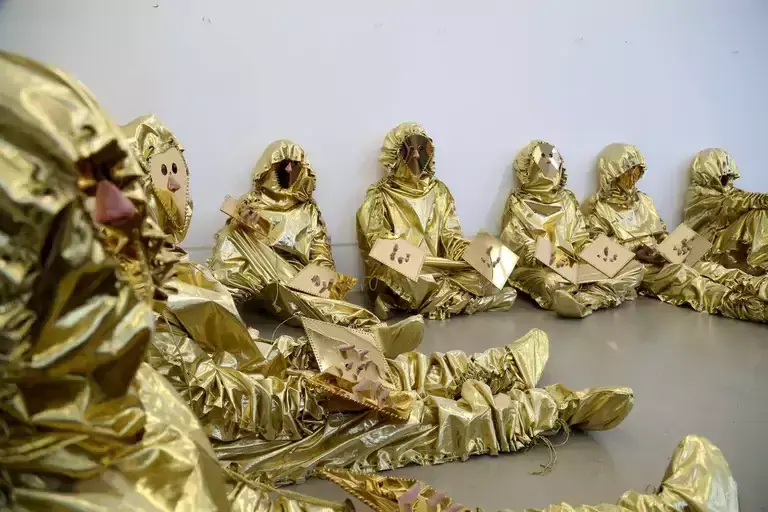 People in golden suits as a part of an artwork